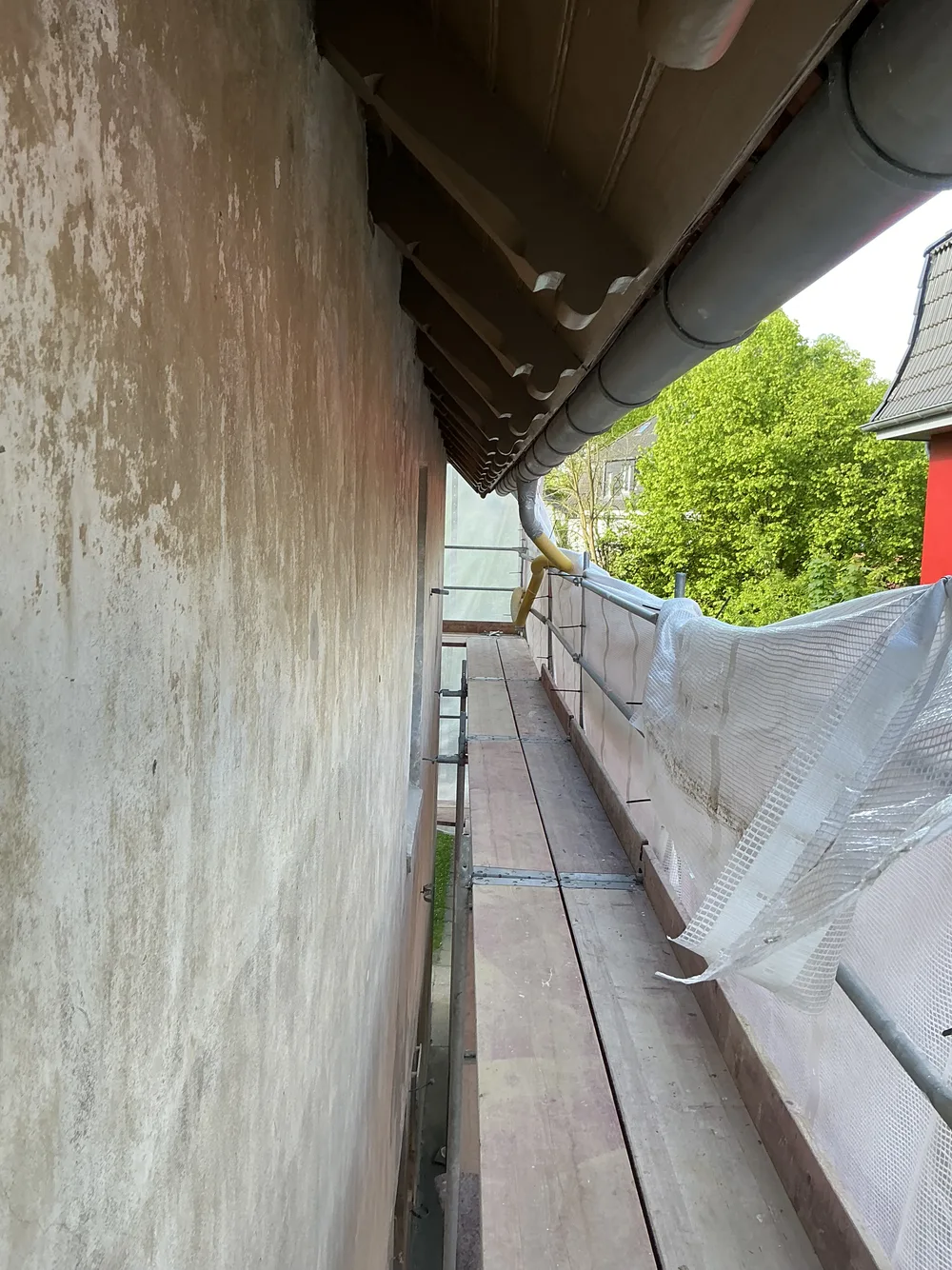 Blick unter das Gerüst an der Traufe vor der Sanierung